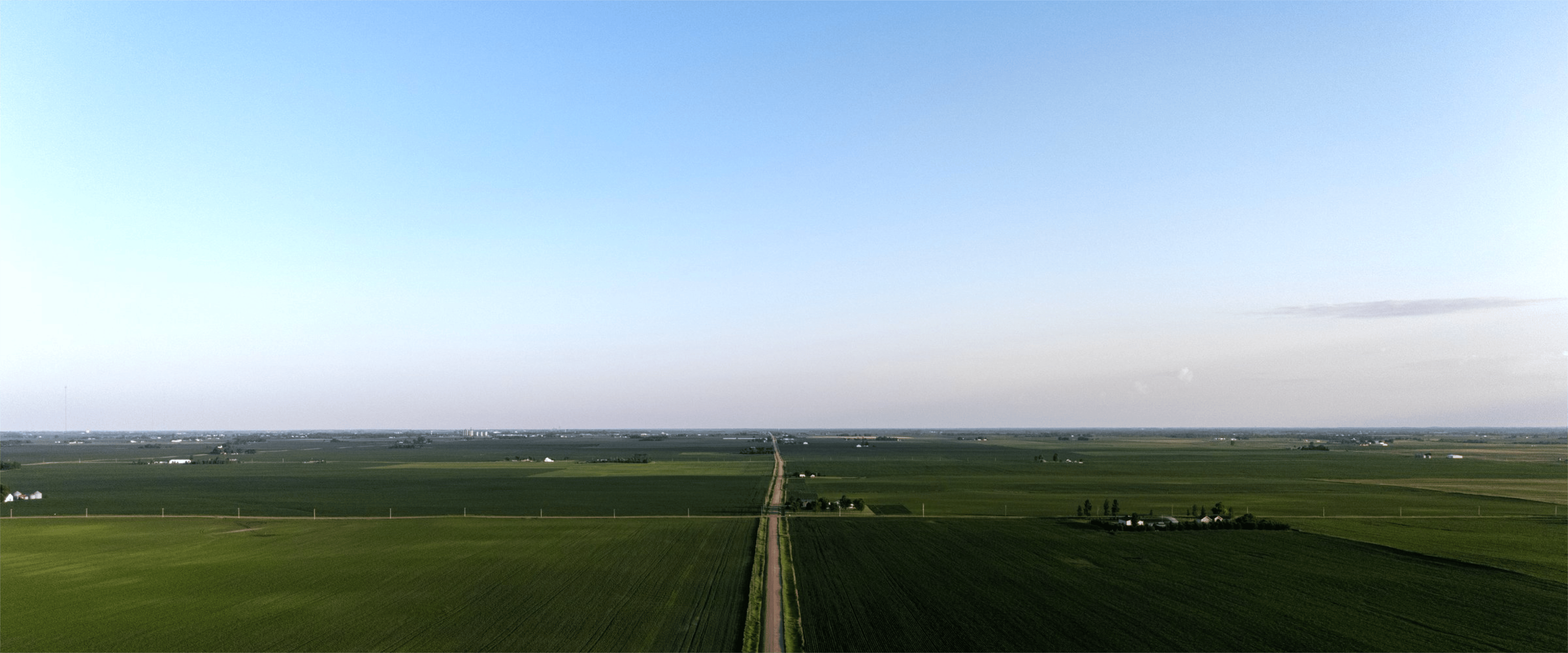 Aerial view of green agricultural fields under a clear sky